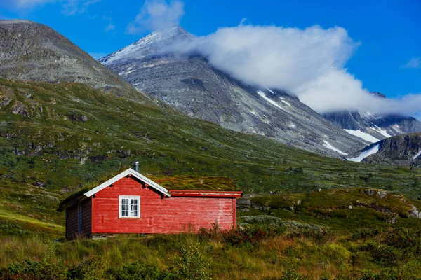 Drewniany domek w dolinie. Kamienia snowy góry. Norwegia. — Zdjęcie stockowe
