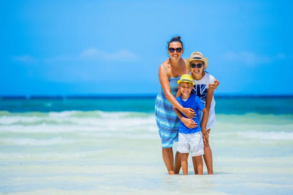 Matka z dwójką dzieci na tropikalnej plaży — Zdjęcie stockowe