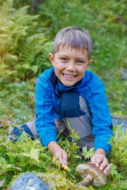 Çocuk ormanda bulunan yabani mantar ile