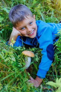 Çocuk ormanda bulunan yabani mantar ile