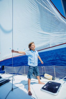 Küçük çocuk yaz gezisinde yelkenli yatında. Seyahat macerası, çocuğuyla yat gezisi..