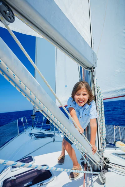 Niño a bordo de un yate de vela en un crucero de verano. Aventura de viaje, yates con niños en vacaciones en familia. — Foto de Stock