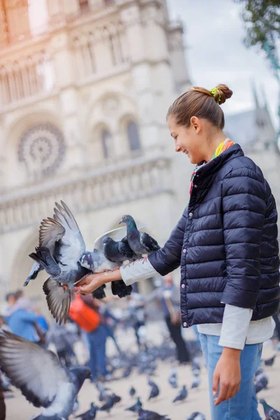 Meisje met vogels in de buurt van Notre Dame de Paris kathedraal in Parijs, Frankrijk — Stockfoto