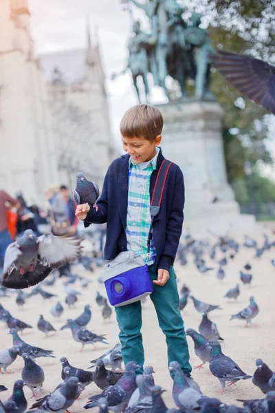 Menino com pássaros perto da catedral de Notre Dame de Paris em Paris, França — Fotografia de Stock