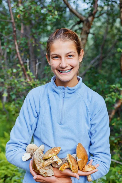 Meisje met wilde paddenstoelen gevonden in het bos — Stockfoto