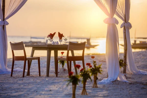 Romantic dinner setting on the beach at sunset — Stock Photo, Image