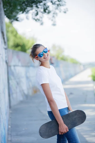 ラフの通り壁にポーズのジーンズ空白の白い t シャツを着ている少女 — ストック写真