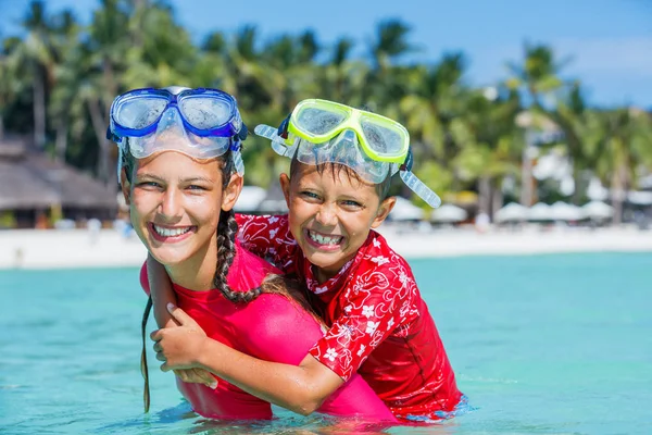 Gelukkige kinderen spelen in de zee. Kinderen hebben plezier buiten. Zomervakantie en gezond levensstijl concept — Stockfoto