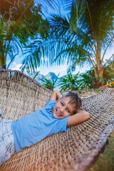 Мальчик отдыхает на тропическом пляже в гамаке . — стоковое фото