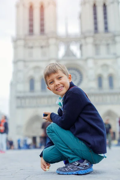 Boy with near Notre Dame de Paris cathedral in Paris, France