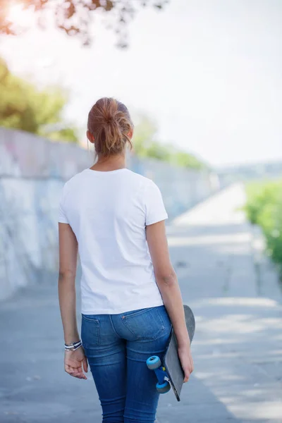 后视图的女孩穿着白色的空白 t 恤，牛仔裤粗糙街道墙构成 — 图库照片