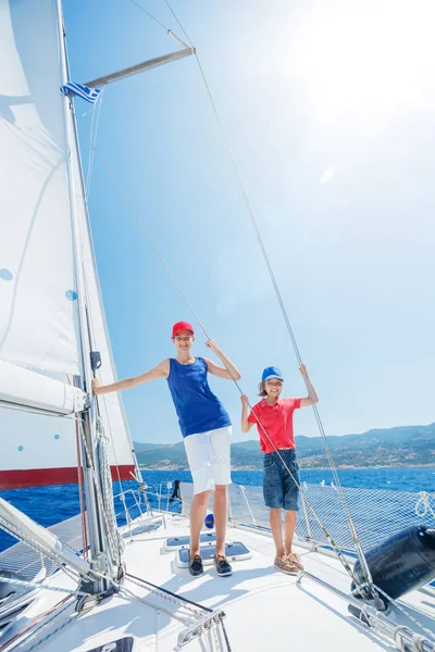 Hermano y hermana a bordo de yate de vela en crucero de verano. Aventura de viaje, yates con niños en vacaciones en familia . — Foto de Stock