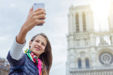 Genç turist kız selfie Notre Dame de Paris Katedrali ile alıyor. Fransa.