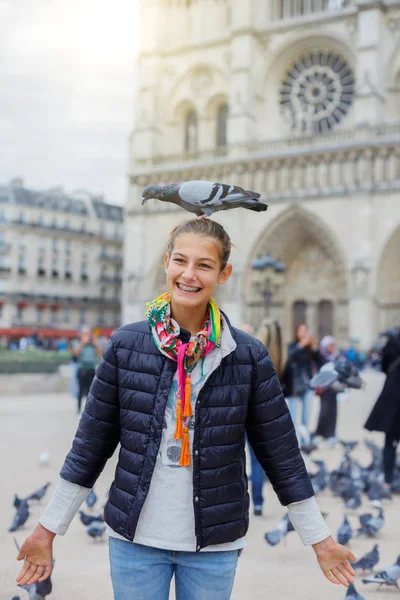 Niña con pájaros cerca de la catedral de Notre Dame de Paris en Paris, Francia — Foto de Stock