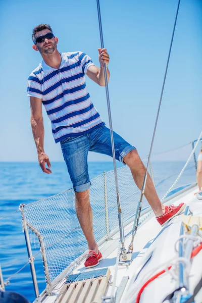 Genç adam yelkenli yat