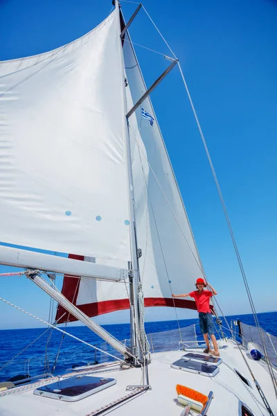 Küçük çocuk yaz gezisinde yelkenli yatında. Seyahat macerası, çocuğuyla yat gezisi..