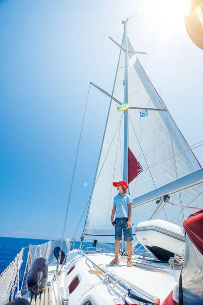 Menino a bordo do iate à vela no cruzeiro de verão. Viagem aventura, iatismo com criança em férias em família. — Fotografia de Stock