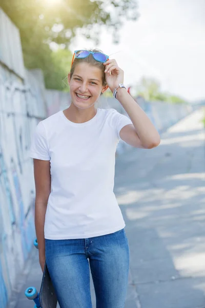 Dívka, která nosí prázdné bílé tričko, džíny představují hrubé zdi ulice — Stock fotografie