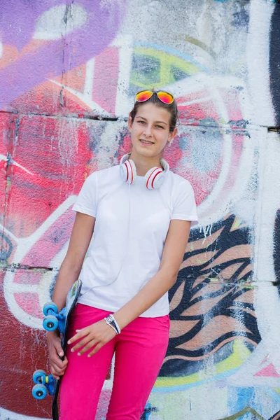 Дівчина в порожній білій футболці, джинси позує на грубу вуличну стіну — стокове фото