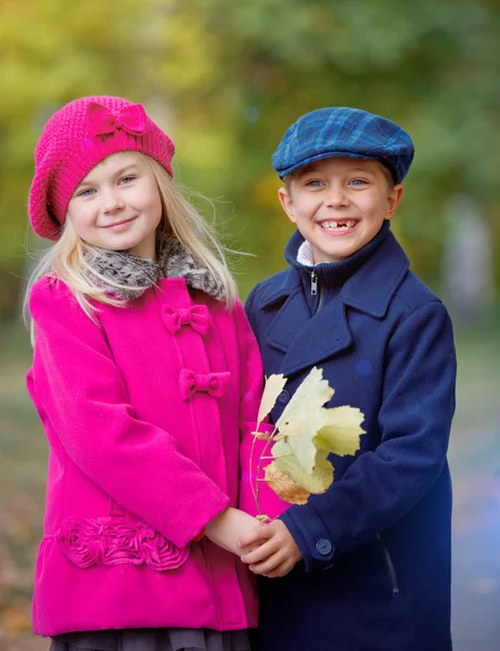 Enfants marchant dans un beau parc d'automne par une chaude journée ensoleillée d'automne . — Photo