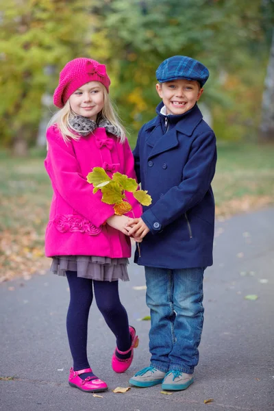 Enfants marchant dans un beau parc d'automne par une chaude journée ensoleillée d'automne . — Photo