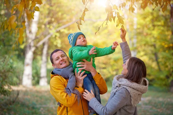 Família feliz jogando no parque de outono — Fotografia de Stock