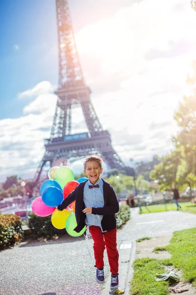 Fiú csomó színes léggömbök Párizsban, az Eiffel-torony közelében. — Stock Fotó