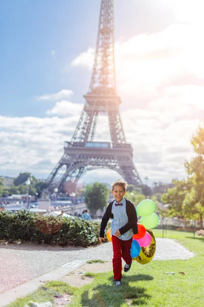 Fiú csomó színes léggömbök Párizsban, az Eiffel-torony közelében. — Stock Fotó