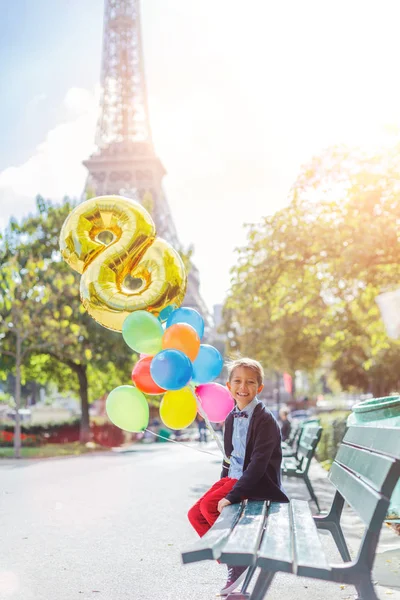 Jongen met bos van kleurrijke ballonnen in Parijs in de buurt van de Eiffeltoren. — Stockfoto