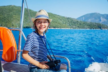 Küçük çocuk yaz gezisinde yelkenli yatında. Seyahat macerası, çocuğuyla yat gezisi..