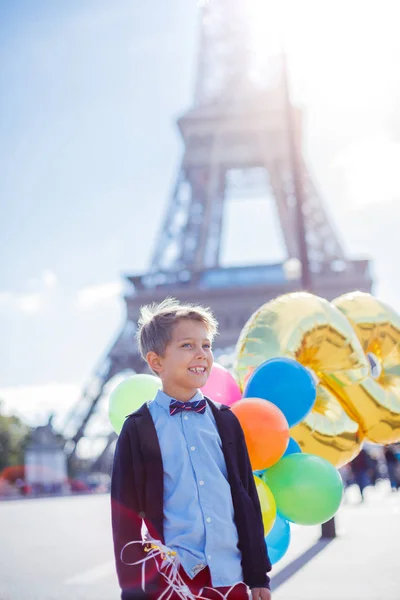 Fiú csomó színes léggömbök Párizsban, az Eiffel-torony közelében. — Stock Fotó