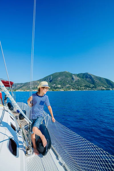 Egy kisfiú a vitorlás jachton a nyári hajóúton. Utazás kaland, jachtozás gyermekkel családi nyaralás. — Stock Fotó