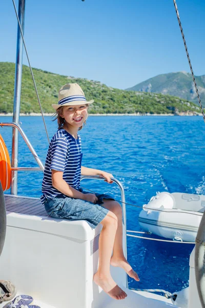Маленький хлопчик на борту вітрильної яхти в літньому круїзі. Подорожі пригоди, яхтинг з дитиною на сімейні канікули . Ліцензійні Стокові Фото