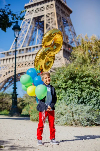 Fiú csomó színes léggömbök Párizsban, az Eiffel-torony közelében. — Stock Fotó