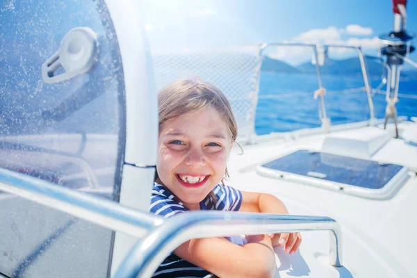 Маленький хлопчик на борту вітрильної яхти в літньому круїзі. Подорожі пригоди, яхтинг з дитиною на сімейні канікули . Ліцензійні Стокові Зображення