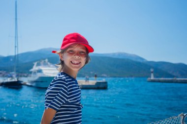 Küçük çocuk yaz gezisinde yelkenli yatında. Seyahat macerası, çocuğuyla yat gezisi..