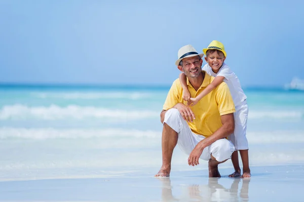 Far med sin son på stranden — Stockfoto