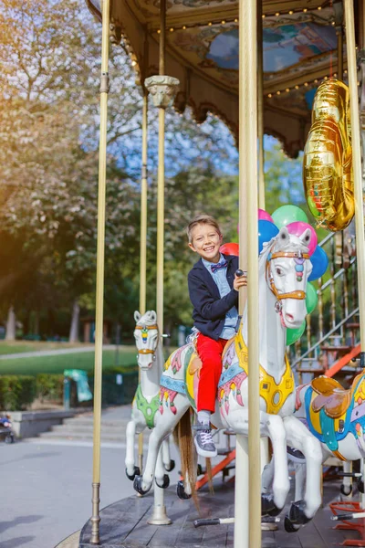 Jongen met bos van kleurrijke ballonnen op de carrousel in Parijs. — Stockfoto