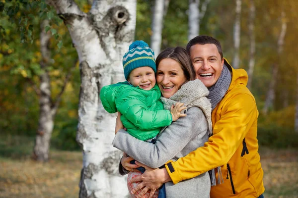 Família feliz jogando no parque de outono — Fotografia de Stock