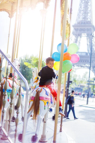 Boy with bunch of colorful balloons on the carousel in Paris. — Stock Photo, Image