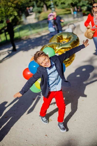 Ragazzo con mazzo di palloncini colorati a Parigi — Foto Stock