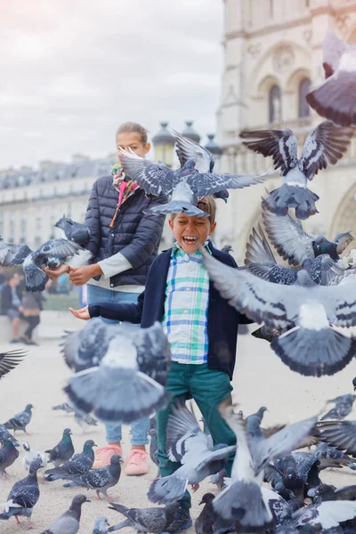 เด็กชายกับนกน้องสาวของเขา ใกล้กับโบสถ์ Notre Dame de Paris ในปารีส ฝรั่งเศส — ภาพถ่ายสต็อก