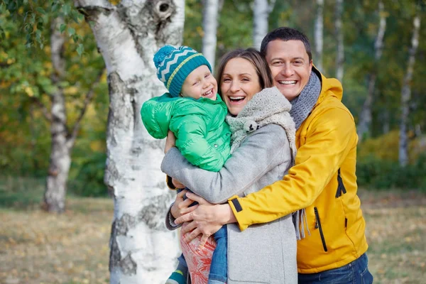 Família feliz jogando no parque de outono — Fotografia de Stock