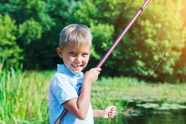 Solitario piccolo bambino pesca sul fiume — Foto Stock