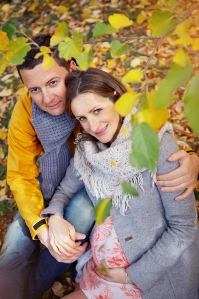 W ciąży kobieta i mężczyzna relaksujący w jesienny park — Zdjęcie stockowe
