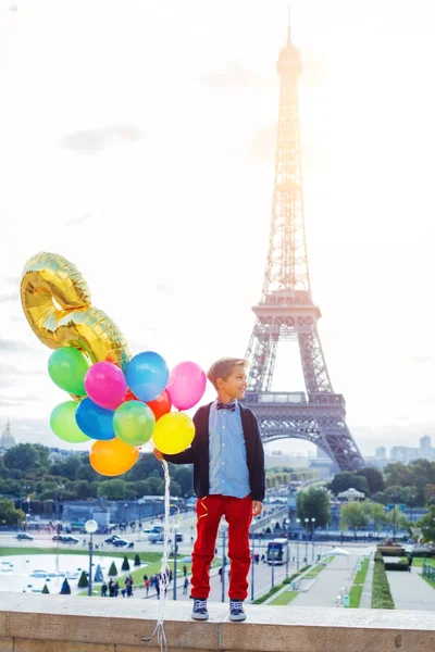 Menino com um monte de balões coloridos em Paris perto da Torre Eiffel . — Fotografia de Stock