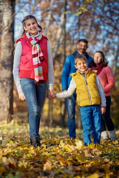 Happy family walking in autumn park — Stock Photo, Image