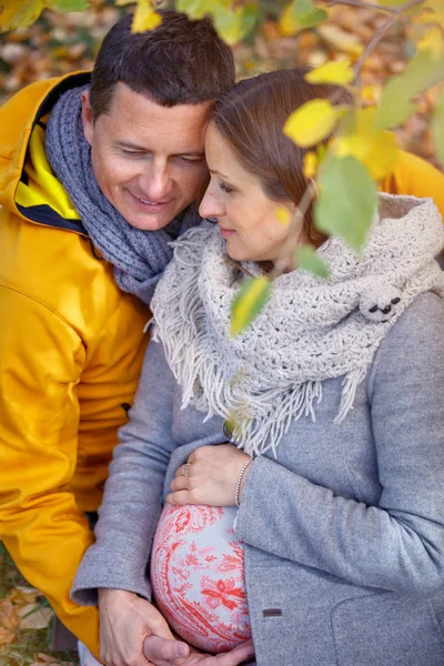 Donna incinta e uomo rilassante al parco autunnale — Foto Stock