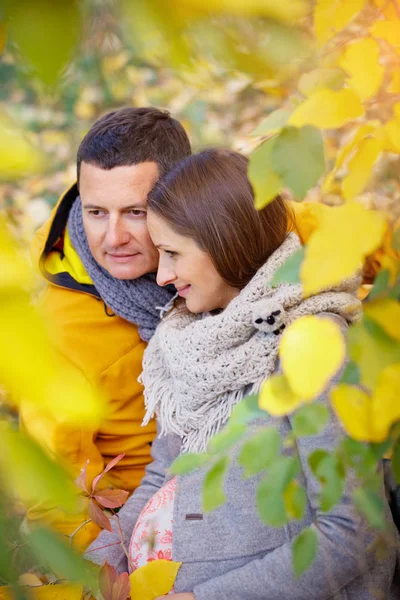 Donna incinta e uomo rilassante al parco autunnale — Foto Stock