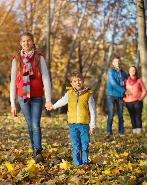 Família feliz andando no parque de outono — Fotografia de Stock